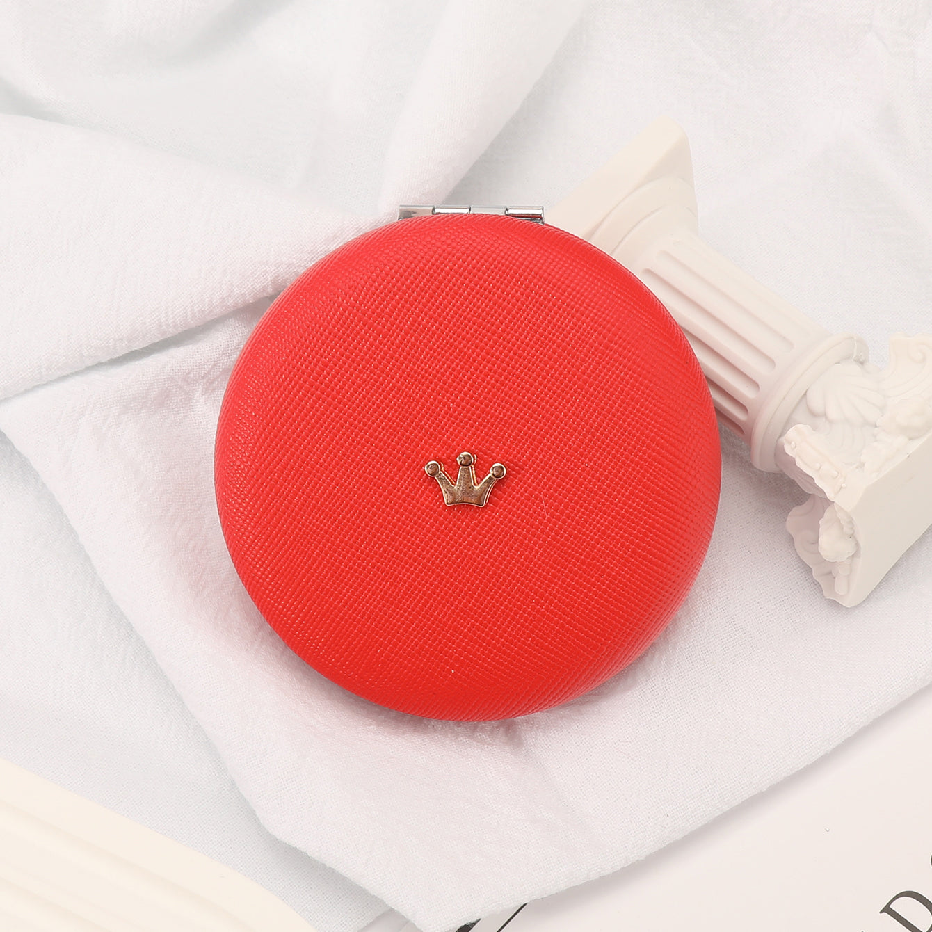 A 70* 70mm round PU leather bread mirror with small metal accessories and customizable patterns. It has a silver plated frame. The leather colors are available in black, red, khaki, and off-white pink.