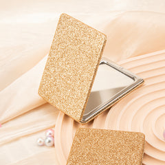 Chic 2X Magnifying Double-sided Makeup Mirror with Metal Frame, Silver Electroplating, and Glitzy Glitter Leather Coating. Compact 60*85mm Size for On-the-Go Glam. Ideal Gift for Holidays, Birthdays, and Weddings.